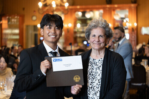 a man holding a certificate and smiling