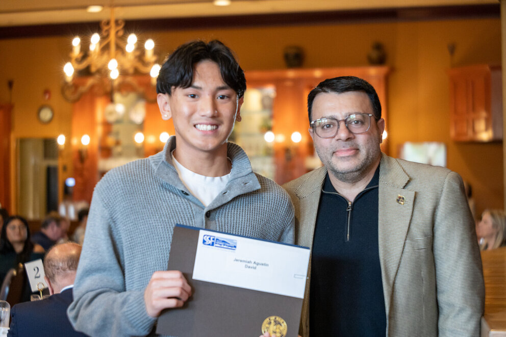 a man holding a certificate and smiling