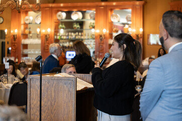 a woman holding a microphone in front of a crowd of people
