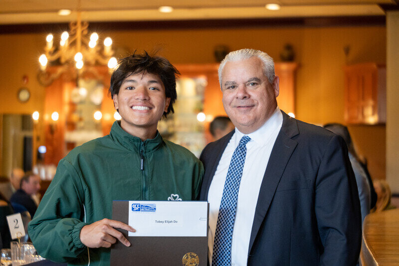 a man holding a plaque with a man in a suit