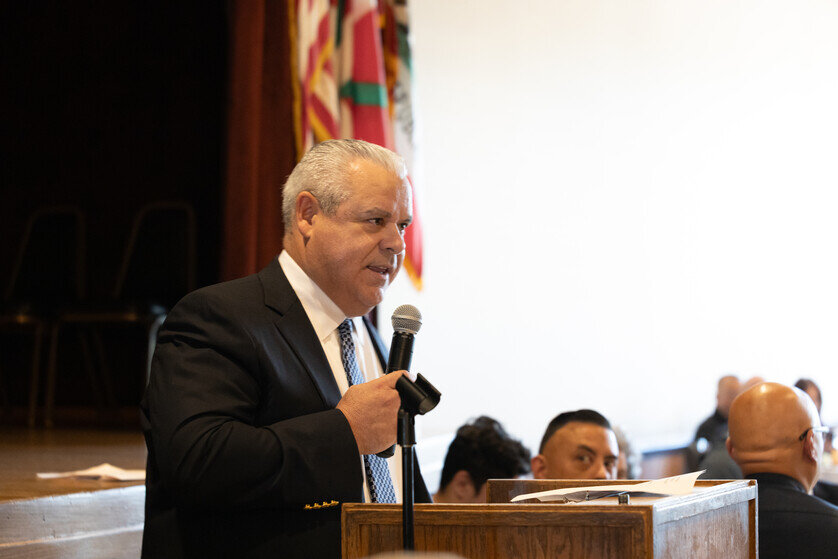 a man standing at a podium holding a microphone