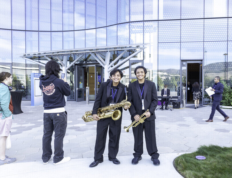 a group of people holding instruments in front of a building