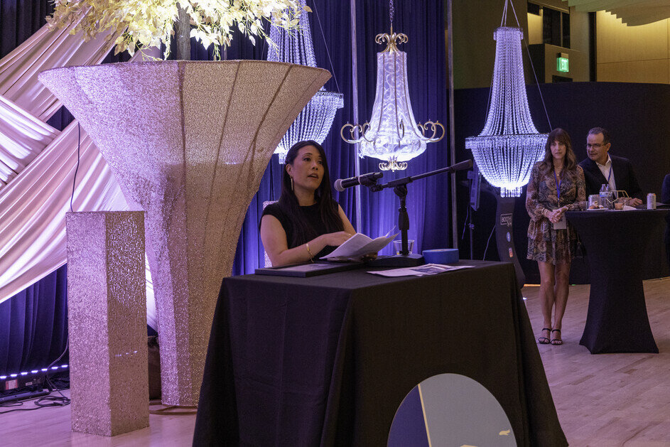 a woman sitting at a podium with a microphone