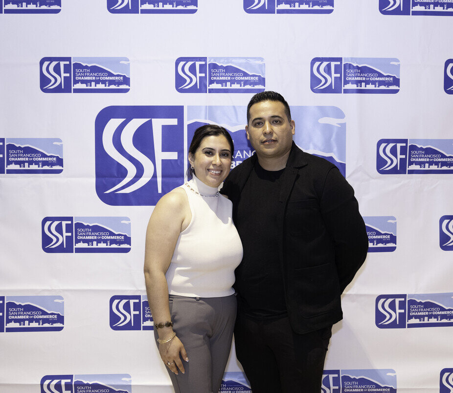 a man and woman standing in front of a white backdrop