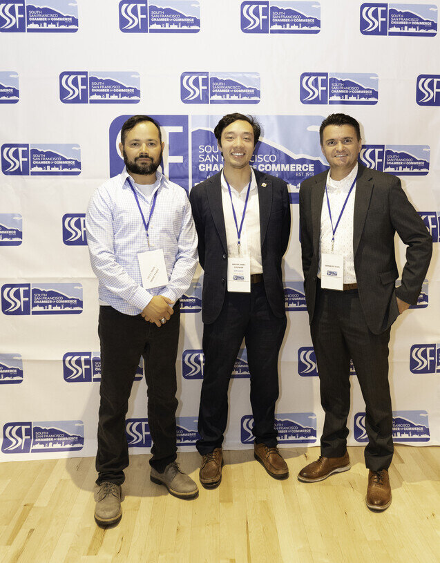 a group of men standing in front of a wall with logos