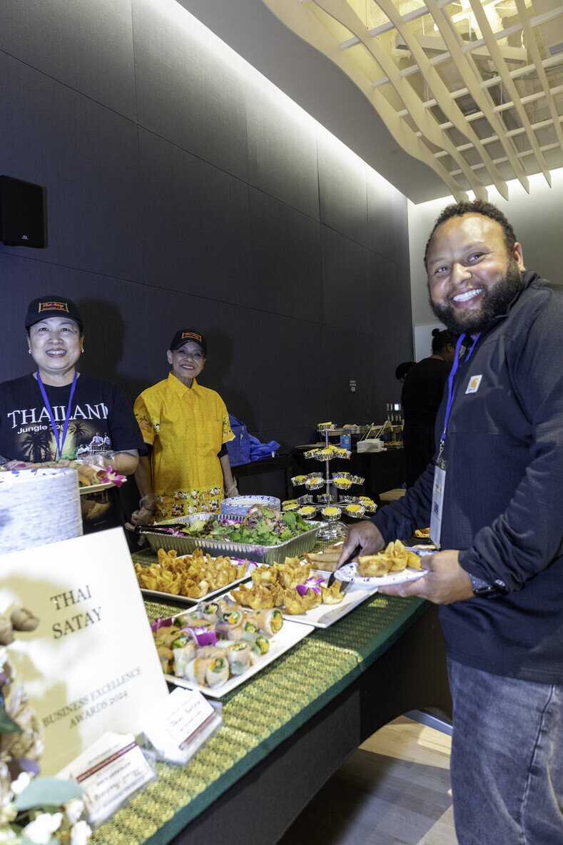 a group of people standing in front of a table full of food