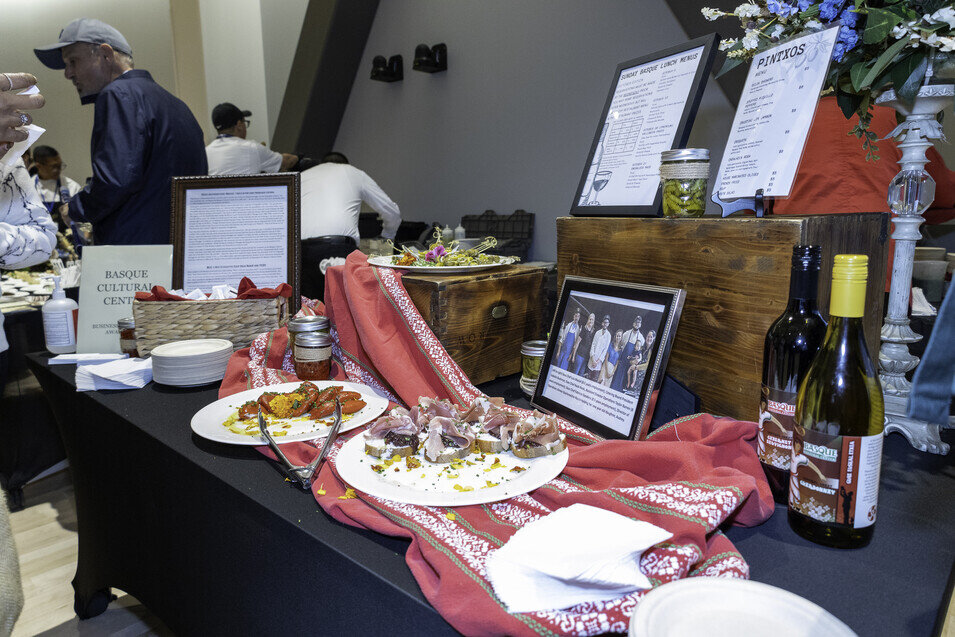 a table with plates of food and a picture of people in the background