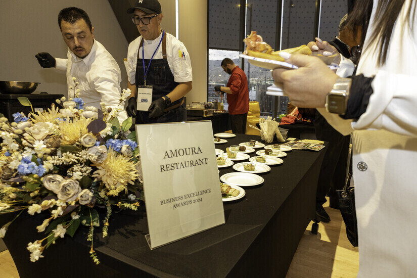 a group of people standing around a table with plates of food