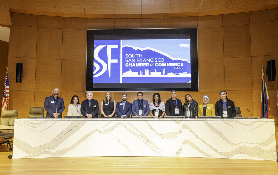 a group of people standing in front of a large screen