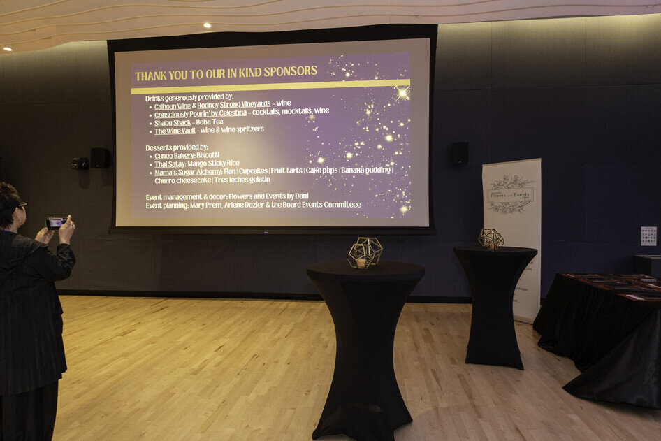 a room with a large screen and tables