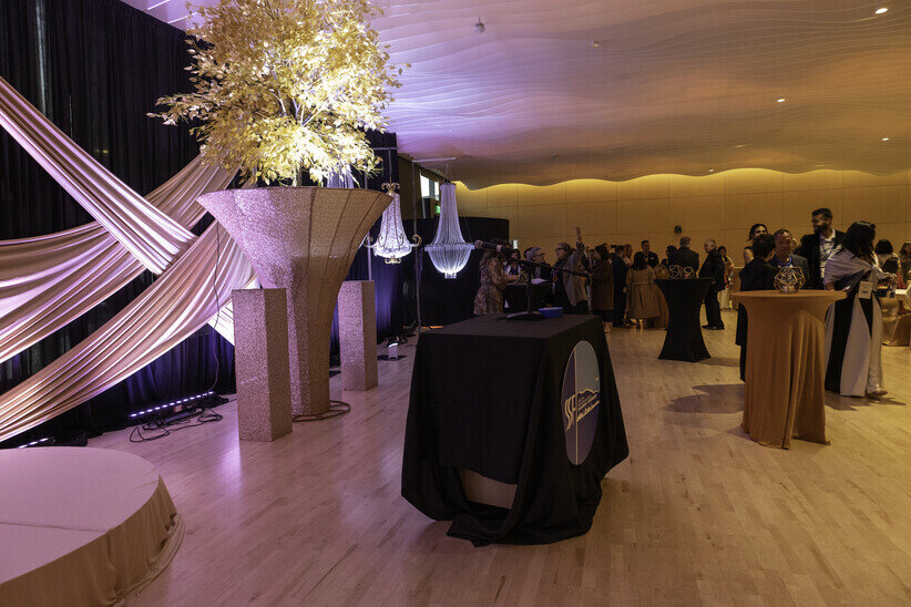 a group of people in a room with a table and a black tablecloth