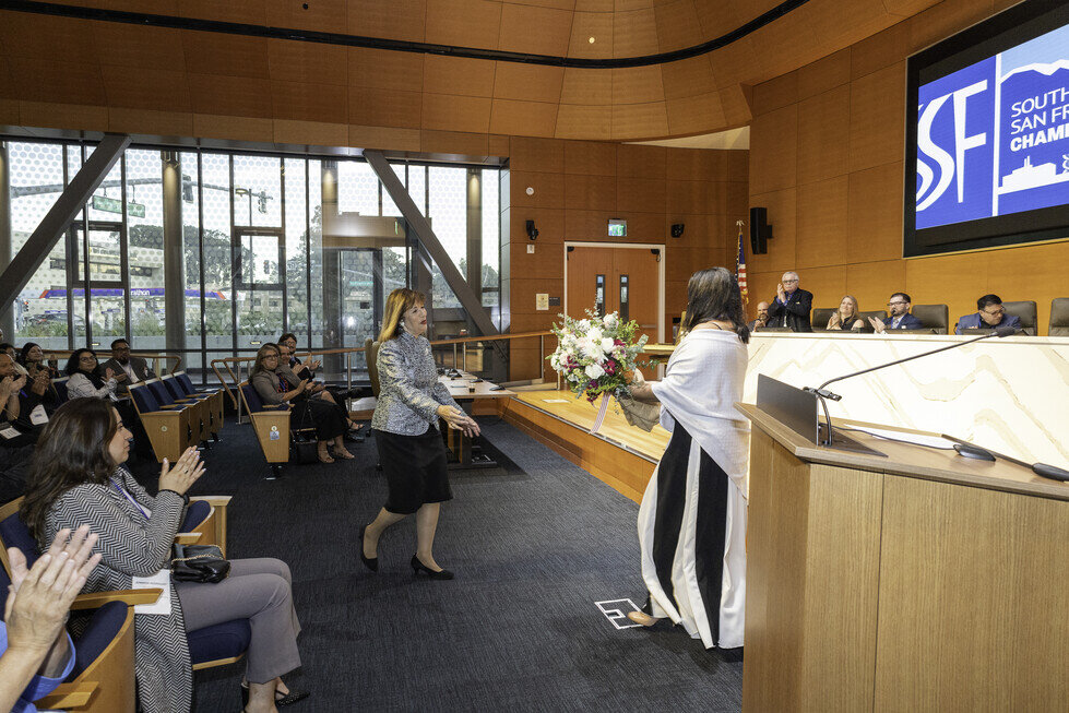 a woman standing in front of a podium with a bouquet of flowers
