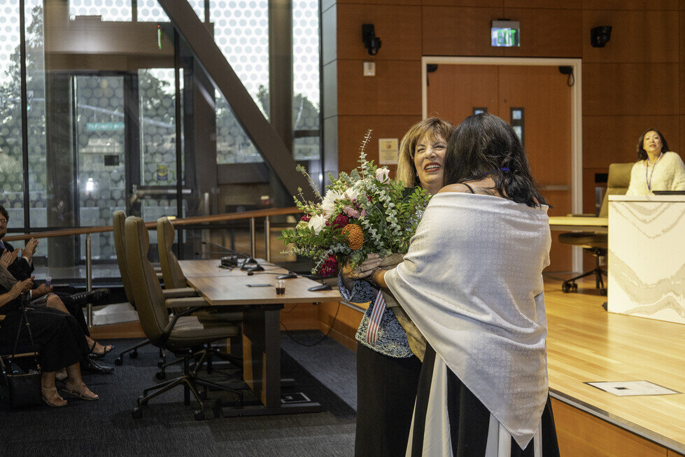 two women holding flowers in a room