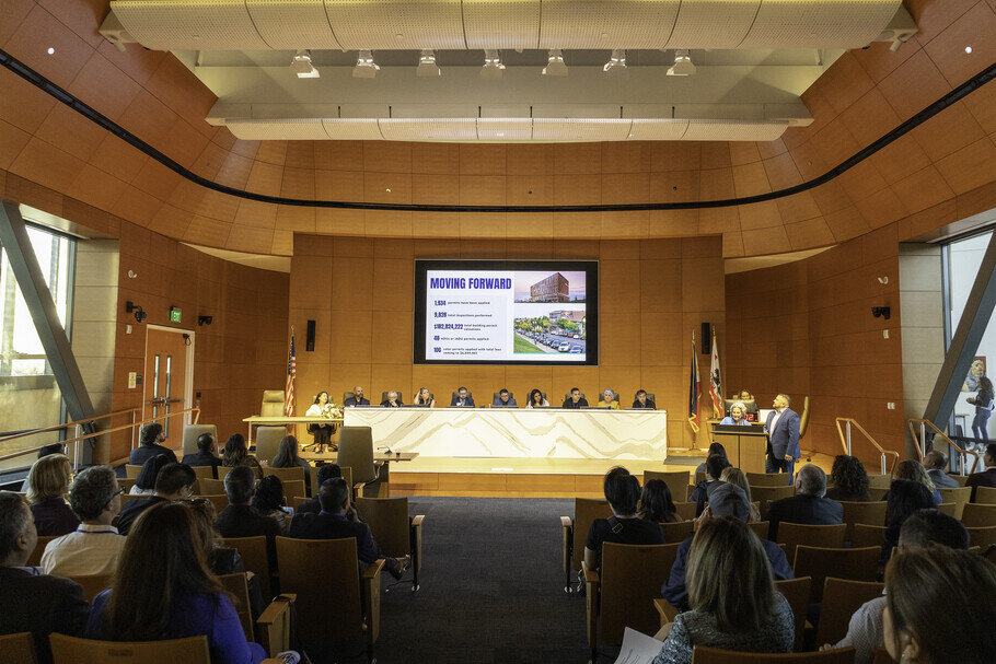 a group of people in a room with a screen